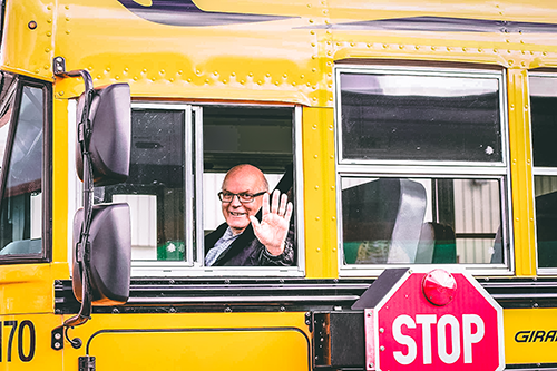 Badder School Bus Driver Waving from driver seat