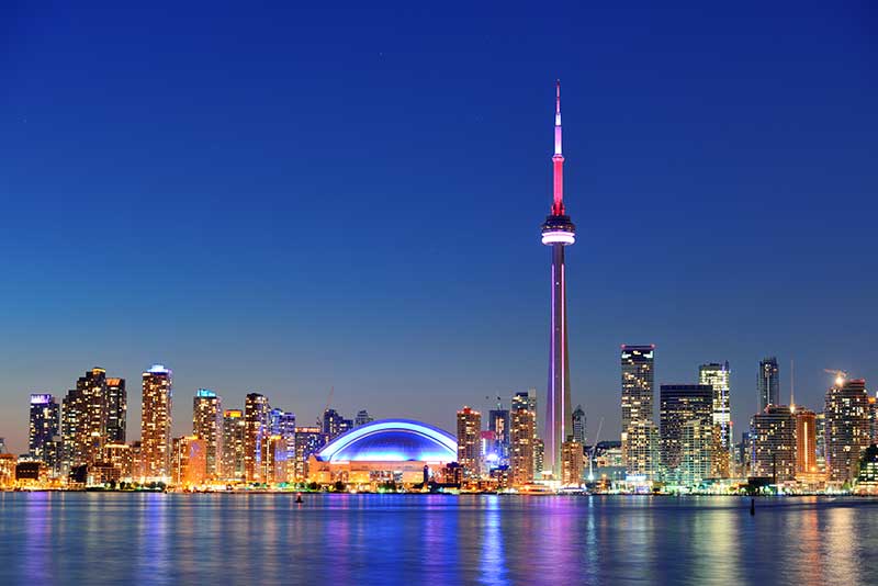 Toronto skyline lit up with pink and blue lights